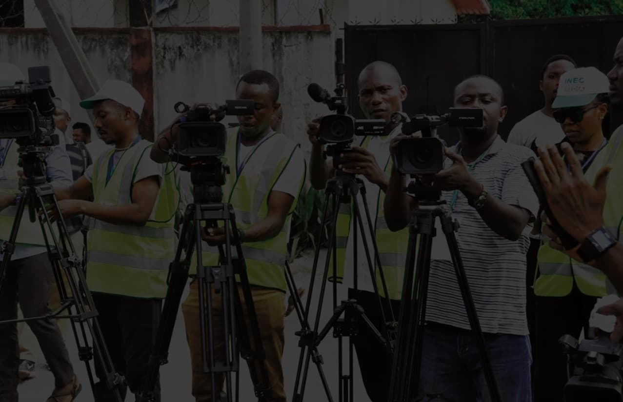 Journalists in INEC accreditation vests filming at an election event